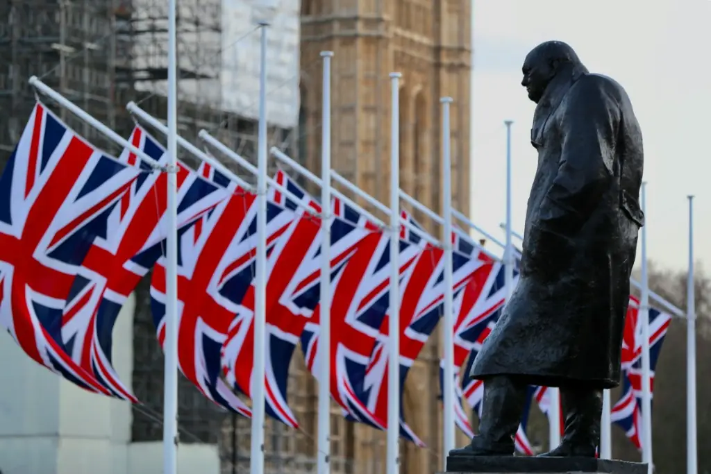 Statue of Winston Churchill outside the Houses of Parliament with Union flags in the background